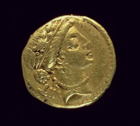 Aureus (anverso) acuñado por Julio César (110-44 a.C.) que representa una cabeza femenina a la derecha con una corona de roble y diadema